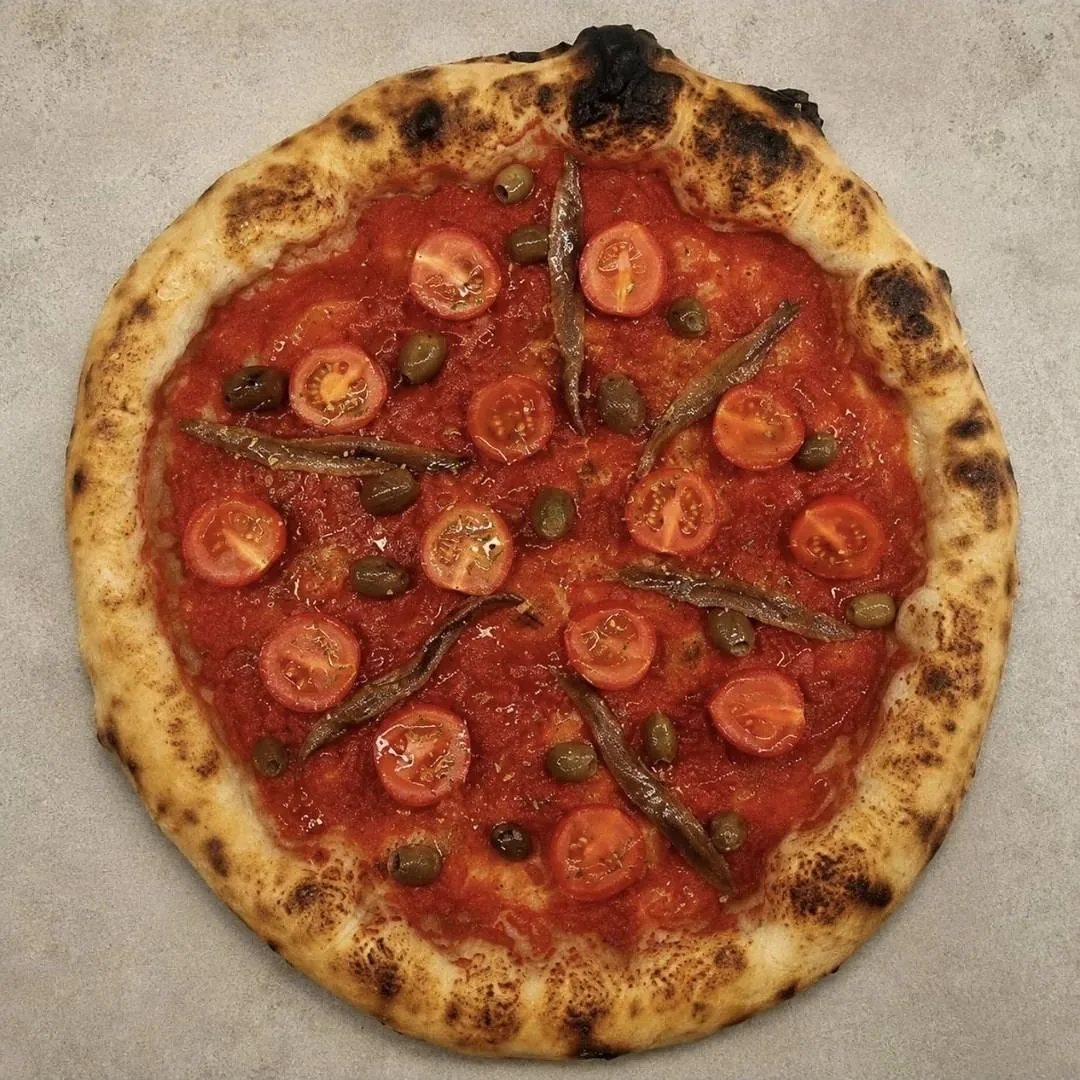 Pizza rossa con pomodorini e acciughe