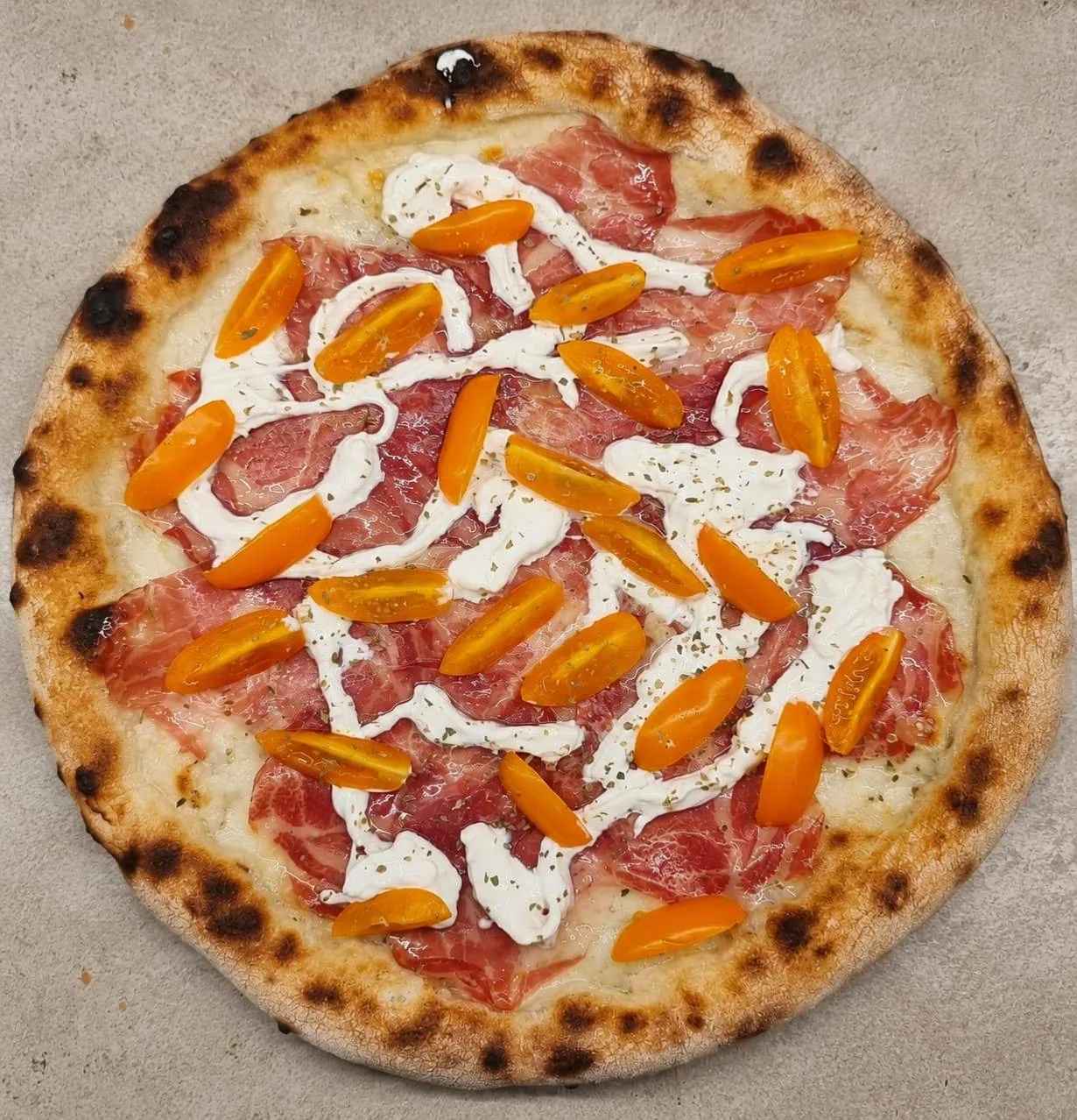 Pizza con capocollo, stracciatella e pomodorini gialli